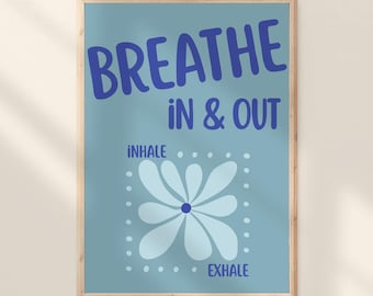 May include: A rectangular wall art print with a light blue background featuring the dark blue text BREATHE IN & OUT at the top. Below, a light blue flower graphic is centered within a dotted square border, with the words INHALE and EXHALE printed.