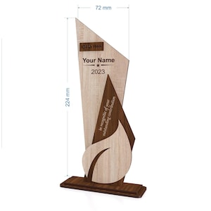 May include: A wooden trophy with a light wood grain finish, featuring a dark wood accent and base. The trophy is 224 mm tall and 72 mm wide. Text includes "Your Name", "2023", and "in recognition of your outstanding contribution."