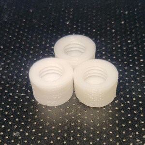 Puede incluir: Tres tapones de botella de pl&aacute;stico blanco con un dise&ntilde;o roscado.