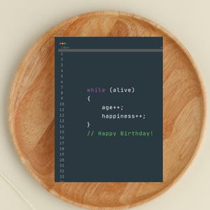 May include: A dark teal-colored graphic with computer code that reads "while (alive) { age++; happiness++; } // Happy Birthday!" on a wooden plate.