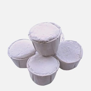 May include: A stack of four white, paper-lined cups filled with a white, powdery substance. The cups are arranged in a slightly overlapping manner, with the contents visible.
