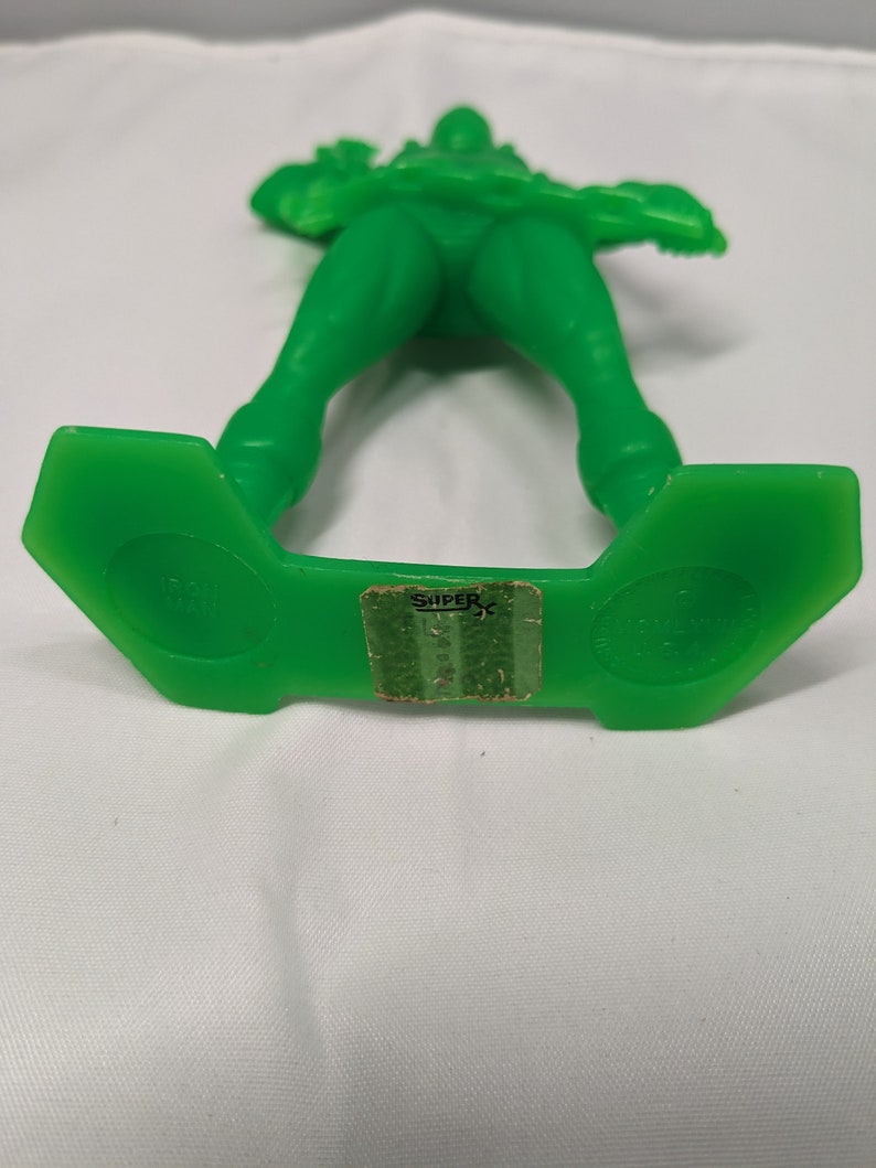 May include: Green plastic toy soldier with a rifle, standing on a green base with the word "SUPER" printed on it.