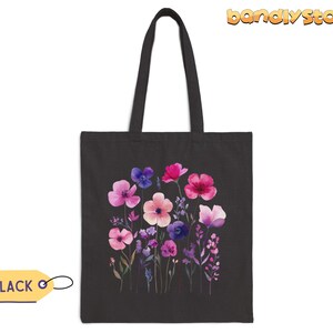 May include: Black tote bag with a floral design featuring pink, purple, and blue watercolor flowers. The flowers are arranged in a bouquet and have a whimsical feel.