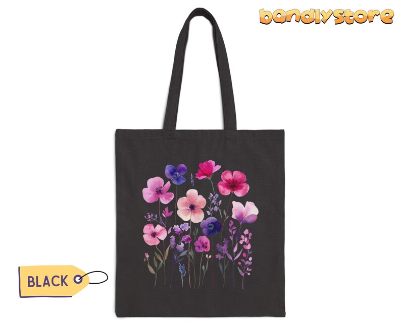 May include: Black tote bag with a floral design featuring pink, purple, and blue watercolor flowers. The flowers are arranged in a bouquet and have a whimsical feel.