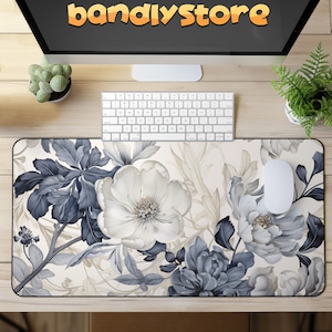 May include: A white and blue floral design mousepad with a white computer mouse on top. The mousepad has a cream background with a floral pattern in shades of blue and white.