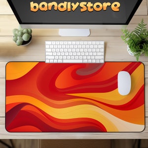 May include: A red and yellow abstract design mousepad with a white computer mouse on top. The mousepad has a wavy, flowing pattern.