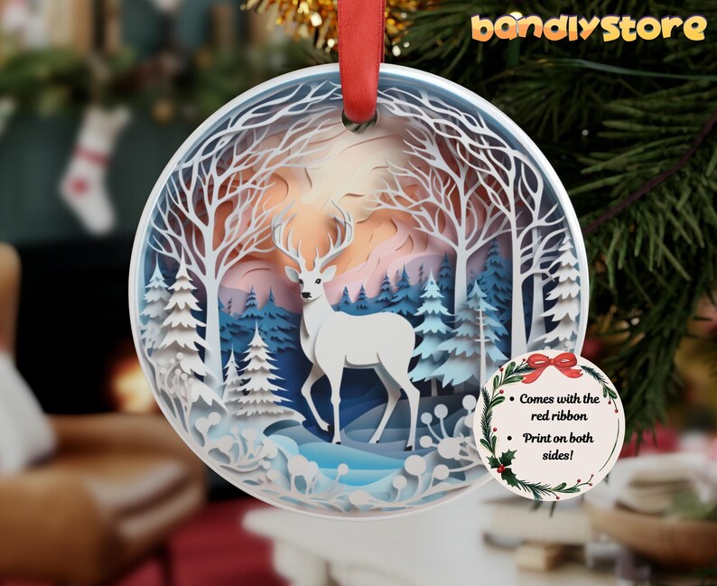 May include: White papercraft deer ornament with a winter forest scene. The ornament is round and has a red ribbon attached. The text on the ornament reads "Comes with the red ribbon. Print on both sides!"
