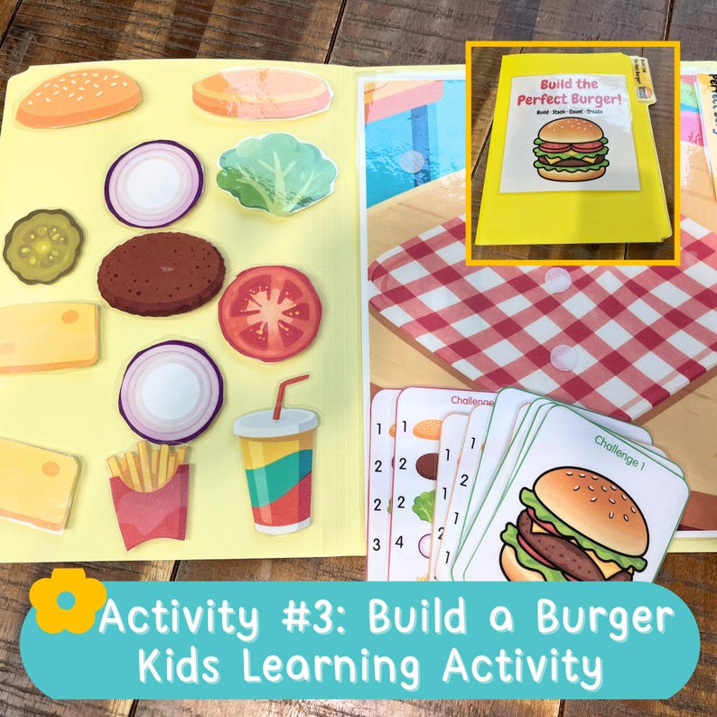 May include: A yellow folder containing a Build the Perfect Burger learning activity with various food-shaped stickers including a bun, lettuce, tomato, onion, pickle, cheese, fries, and a drink, alongside challenge cards and a red checkered mat.