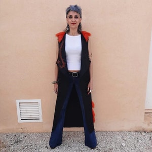 Long black denim vest with coral synthetic fur appliqués.