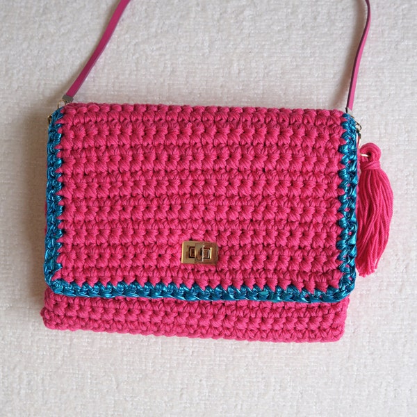 Petit sac à main de couleur fuchsia réalisé au crochet décoré d'un pourtour bleu en fil métallique brillant Fait en France