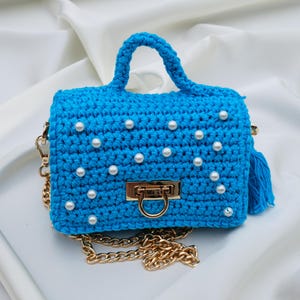 Adorable petit sac bleu azur au crochet doublé d'un tissu coton orange et décoré de petites perles nacrées Fait main en France.