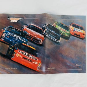May include: Official program for the Brickyard 400 race. The image shows a spread with several race cars in motion. The cars are various colors, including red, blue, and green, with sponsor logos. The NASCAR logo is visible.