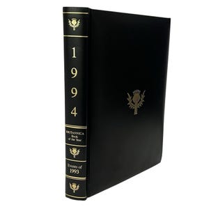 May include: A black "Britannica Book of the Year" from 1994. The spine features the year and gold accents. The cover has a gold thistle emblem.
