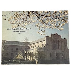 Könnte beinhalten: Eine Vintage-Postkarte mit einem Foto der First United Methodist Church in Winchester, Kentucky. Die Kirche ist ein großes Gebäude aus Backstein mit einem hohen Turm. Die Postkarte ist datiert auf 1983.