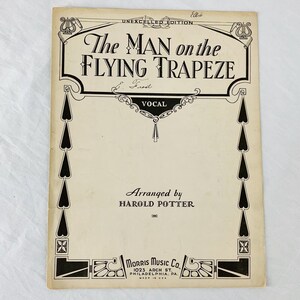 May include: Black and white sheet music cover with a decorative border. The title is "The Man on the Flying Trapeze" by L. Frost. It is arranged by Harold Potter and published by Morris Music Co.