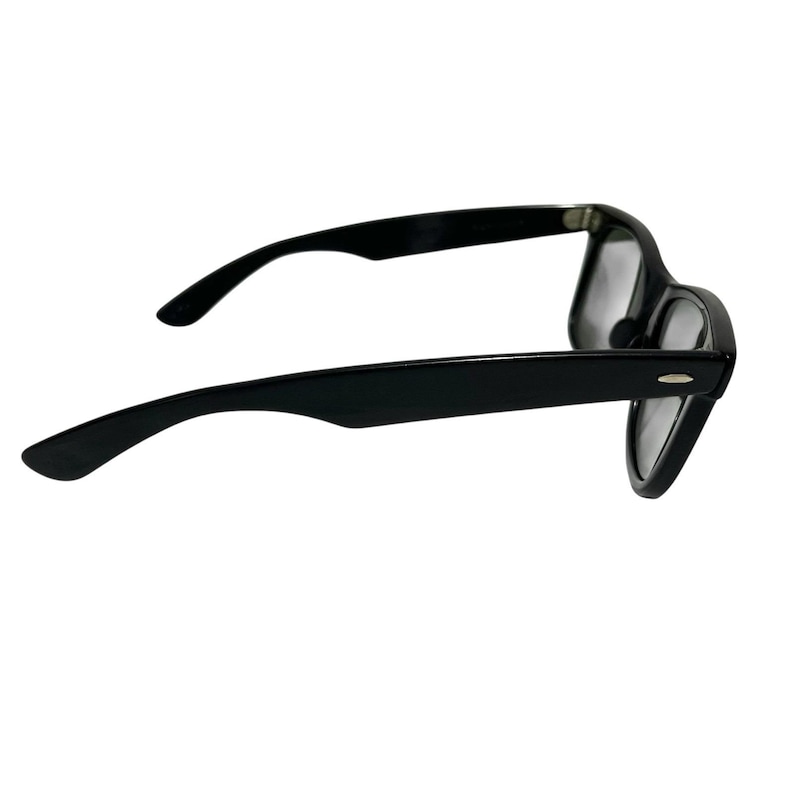 K&ouml;nnte beinhalten: Schwarz gerahmte Brille mit klassischem Design. Die Brille hat eine rechteckige Form und dicke, schwarze Rahmen. Die B&uuml;gel sind ebenfalls schwarz und reichen bis zum Ohr. Die Gl&auml;ser sind klar.