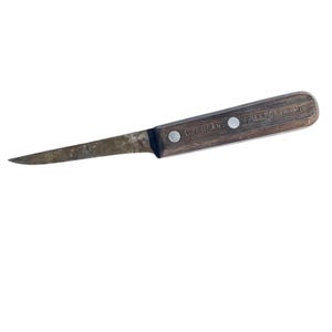 May include: An L.L. Bean knife with a wooden handle and a narrow, pointed blade. The handle is dark brown and secured with two silver rivets. The text "L.L. BEAN FREEPORT ME" is printed on the handle.