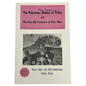 May include: A vintage booklet titled "The Poisonous Snakes of Texas and The First Aid Treatment of Their Bites." The cover features a black and white photo of a snake and pink text. Published by the Texas Game and Fish Commission.
