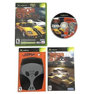 May include: A video game bundle for Xbox featuring Sega GT 2002 and Jet Set Radio Future. The set includes a game case with cover art, a game disc, and two separate game manuals. The cover art displays yellow and white sports cars on a track.