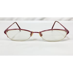 May include: A pair of burgundy metal eyeglasses with a thin, oval frame.