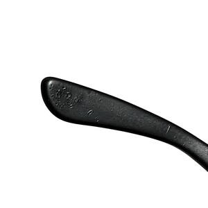 K&ouml;nnte beinhalten: Nahaufnahme eines schwarzen Brillenb&uuml;gels. Der B&uuml;gel ist gebogen und hat eine matte Oberfl&auml;che. Das Ende des B&uuml;gels hat eine abgerundete Form mit kleinen, strukturierten Details. Der Hintergrund ist schlicht wei&szlig;.
