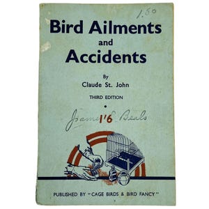 Op de afbeelding: Vintage boek getiteld "Bird Ailments and Accidents" door Claude St. John, derde editie. De omslag is lichtblauw met donkerblauwe tekst en een afbeelding van een vogelkooi en handen. Het boek heeft een handgeschreven inscriptie en een prijskaartje.