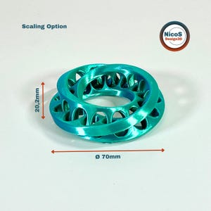 Das Foto zeigt türkisfarbene Möbius-Ringe mit eingezeichneten Abmessungen für Höhe und Durchmesser. Beispielansicht zum digitalen STL-Modell.
