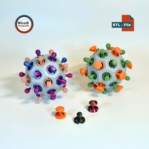 Könnte beinhalten: Zwei 3D-gedruckte, kugelförmige Objekte mit hervorstehenden Elementen in verschiedenen Farben, darunter Orange, Grün und Lila. Die Objekte haben ein geometrisches Design und werden von kleineren, passenden Komponenten begleitet. Das Bild enthält den Text "STL - File" und ein Logo.