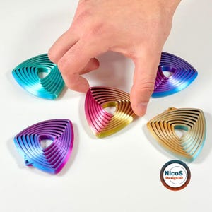 Auf dem Bild bewegt eine Hand die Ringe eines dreieckigen Wobble-Fidget-Schlüsselanhängers. Beispielansicht zum digitalen STL-Modell.