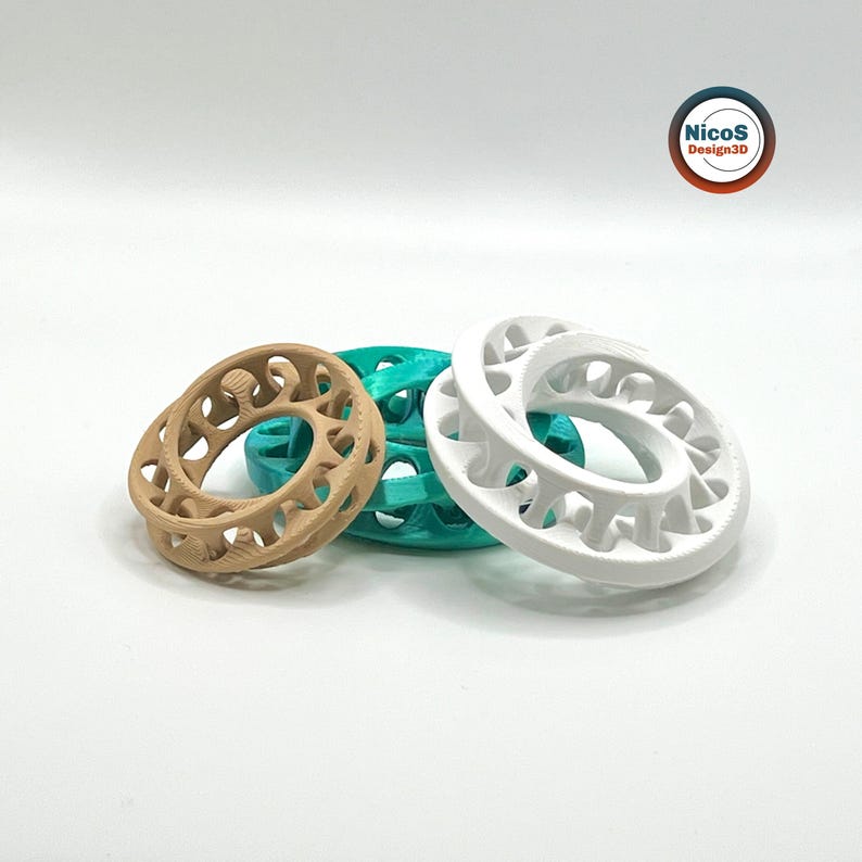 Das Bild zeigt drei Möbius-Ring-Fidgets in Türkis, Weiß und Beige vor weißem Hintergrund. Beispielansicht zum digitalen STL-Modell.