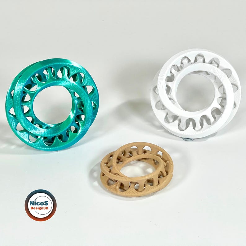 Das Bild zeigt drei Möbius-Ring-Fidgets in unterschiedlichen Farben, schräg in der Draufsicht. Beispielansicht zum digitalen STL-Modell.