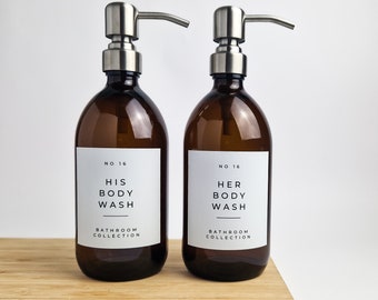 May include: Two amber glass bottles with silver pumps and black labels. The labels read "No. 16 His Body Wash Bathroom Collection" and "No. 16 Her Body Wash Bathroom Collection".