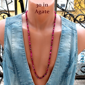 Może przedstawiać: Długi naszyjnik z fasetowanych, różowych koralików z agatu, o długości około 76 cm. Tekst "30 in Agate" jest wyświetlany nad naszyjnikiem.