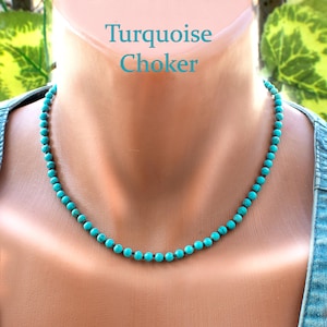 Puede incluir: Un collar gargantilla turquesa con pequeñas cuentas redondas. El collar se muestra en un maniquí. El texto "Turquoise Choker" es visible en la imagen.