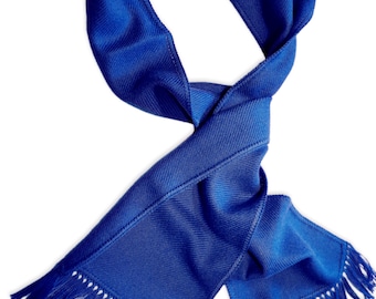 May include: A royal blue scarf with fringed ends. The scarf is folded and tied in a knot.
