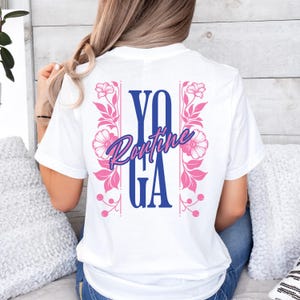 Könnte beinhalten: Weißes T-Shirt mit einem blauen und pinkfarbenen Grafikdesign, auf dem "Yoga Routine" mit floralen Akzenten steht.