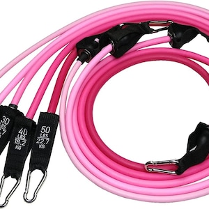 May include: A set of pink resistance bands with black fabric handles and silver metal clips. The bands are in shades of pink, with labels indicating resistance levels from 10 lbs to 50 lbs. The bands are designed for exercise and fitness.