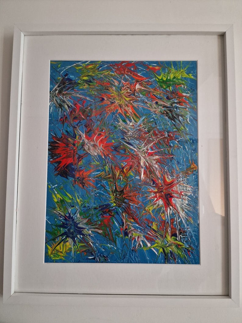 K&ouml;nnte beinhalten: Abstraktes Gem&auml;lde mit blauem Hintergrund und bunten Spritzfarben in Rot, Gelb, Gr&uuml;n und Wei&szlig;.