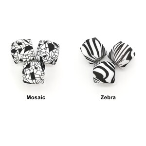 Könnte beinhalten: Sechs quadratische Perlen, drei mit Mosaikmuster und drei mit Zebrastreifen. Die Mosaikperlen haben ein schwarz-weißes geometrisches Muster. Die Zebraperlen haben schwarz-weiße Streifen. Die Wörter "Mosaik" und "Zebra" stehen darunter.