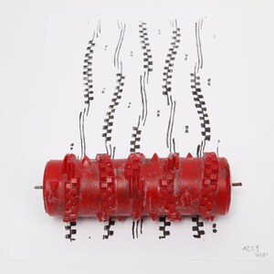 Könnte beinhalten: Eine rote Muster-Farbwalze mit strukturierter Oberfläche und erhabenen geometrischen Formen. Die Walze liegt horizontal und erzeugt vertikale schwarze Tintenspuren auf einer weißen Fläche, mit dem sichtbaren Text 1259 MINI.