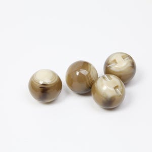 以下が含まれることがあります： 茶色とクリーム色の縞模様の、研磨された球形の石が4つ。 石は滑らかで光沢のある仕上がりで、白い背景に配置されています。 これらの装飾用の石は、家の装飾や工芸品に使用できます。