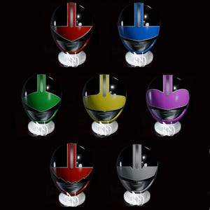 May include: Set of seven helmets in different colors, including red, blue, green, yellow, purple, red, and gray. Each helmet has a black base and a silver stripe down the center.