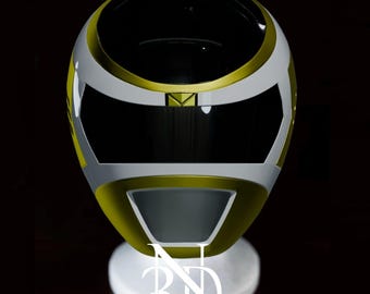 May include: White and gold helmet with a black visor. The helmet is on a white stand with the letters "3D" printed on it.