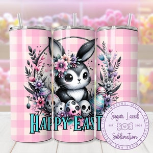 Puede incluir: Un vaso de color rosa y blanco a cuadros con un conejito negro que lleva una corona de flores y sostiene huevos de Pascua. El texto "Happy Easter" está escrito en azul turquesa. El vaso está rodeado de una corona de flores y calaveras.
