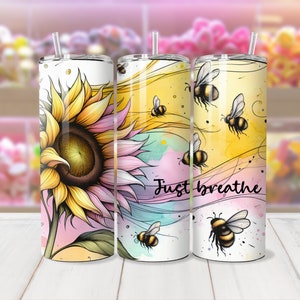 May include: Three stainless steel tumblers with lids and straws. The tumblers feature a watercolor design with sunflowers, bees, and the text "Just Breathe".