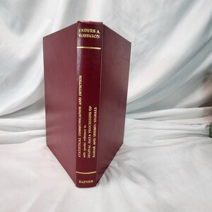 May include: A maroon hardcover book titled "Statistical Communication and Detection" by Enders A. Robinson. The book's spine features gold lettering and the publisher's name, Hafner. The book focuses on digital data processing of radar and seismic signals.