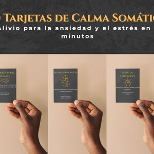Op de afbeelding: Drie donkergrijze kaarten met gouden tekst worden door handen omhoog gehouden. De kaarten hebben verschillende ontwerpen en teksten, waaronder "30 TARJETAS DE CALMA SOMÁTICA" en "Alivio para la ansiedad y el estrés en 5 minutos."