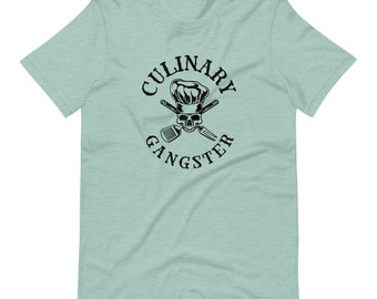 May include: A light blue t-shirt with a black graphic of a skull wearing a chef's hat and crossed kitchen utensils. The text "CULINARY GANGSTER" is written in a circle around the graphic.