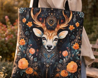 May include: A black tote bag featuring a detailed illustration of a deer with large antlers, surrounded by orange roses and floral elements. The deer has a white face and gold antlers. The bag has black straps and is being carried outdoors.