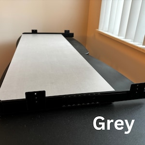 Puede incluir: Una camilla de masaje negra con un rollo de papel gris. La camilla tiene soportes met&aacute;licos negros y un marco negro. La palabra "Grey" est&aacute; escrita en blanco en la parte inferior de la imagen.